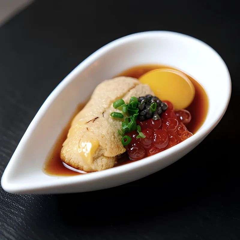 Uni, ikura and a quail yolk sitting in soy in a white spoon dish